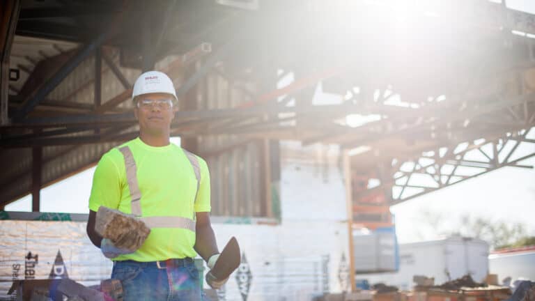  masonry worker holding bricks on jobsite